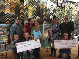 The Marble Family and The Anderson Family displaying their Big Checks in front of the awesome pig bowl collages by Marty Hiser of Westwind Frame and Gallery.  The Actual Checks given to the family were in the amount of $20, 676.42 after more money came in following the initial count. 